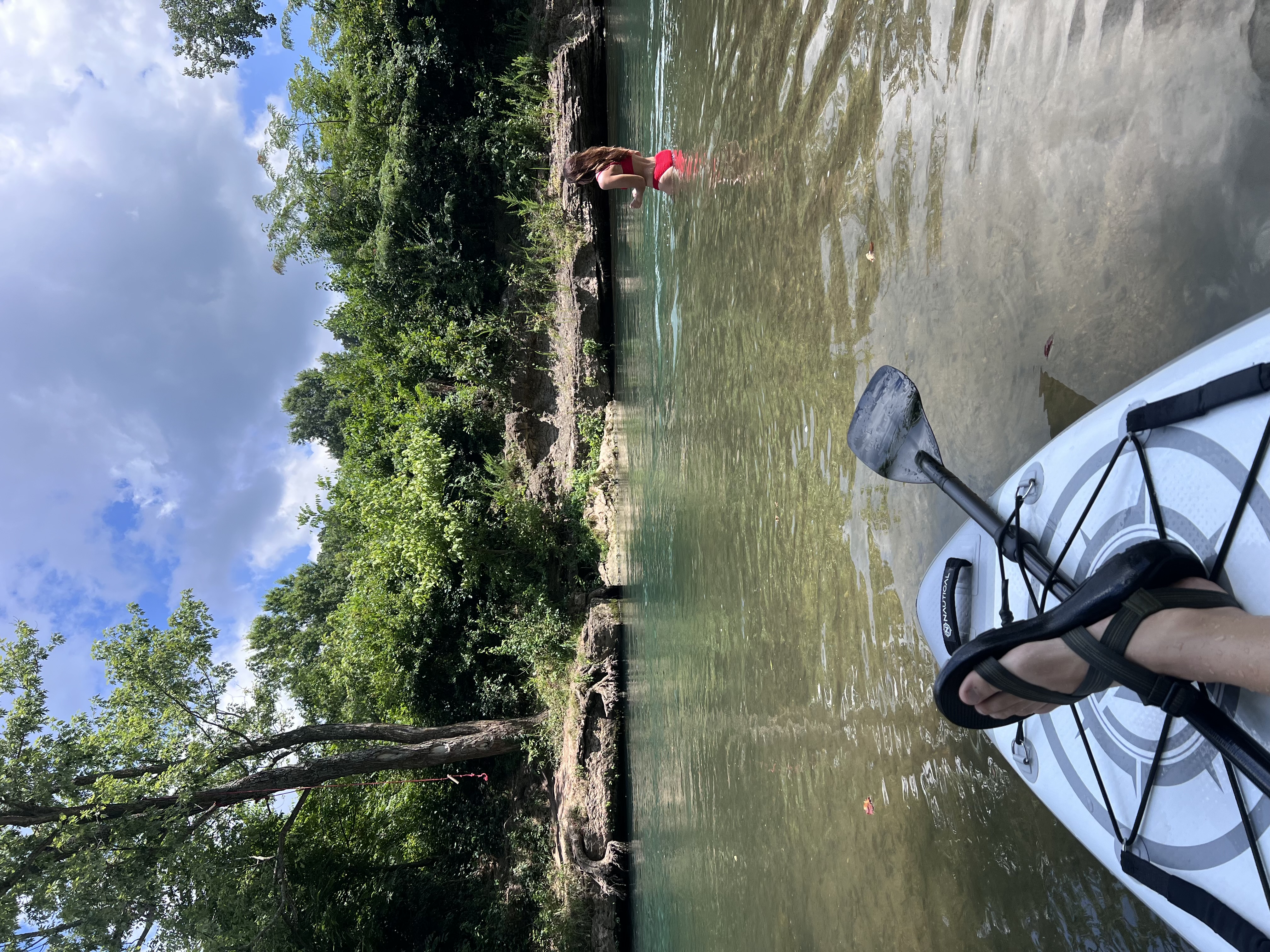 Point-of-view shot from a paddler on a SUP with another paddler wading in Little Sugar Creek